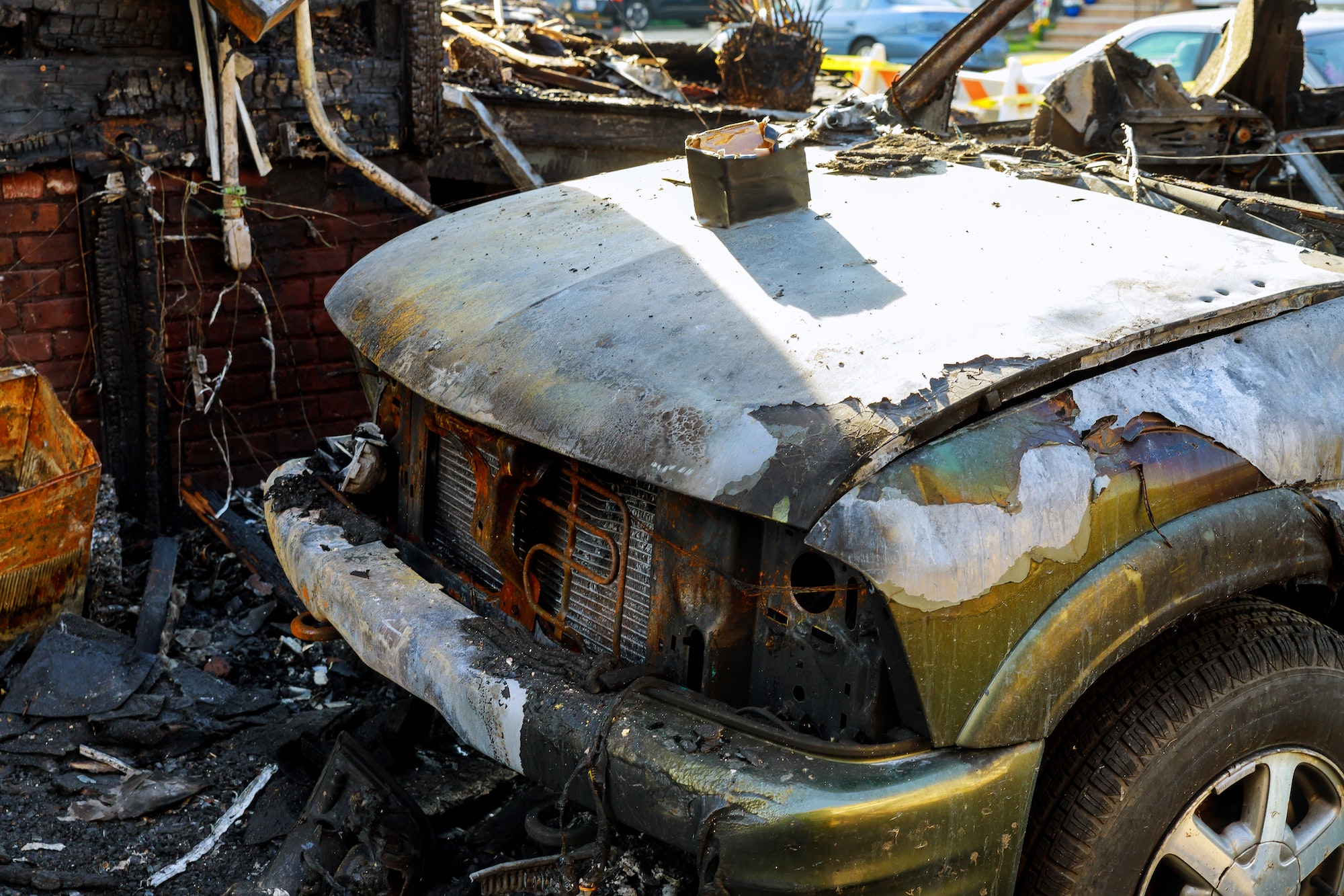 The car after the fire. Burnt out car with an open hood. Engine burned out car wreck after a fire
